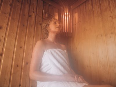 Woman sitting in spa wearing a towel taking steam bath. Woman relaxing in a spa.